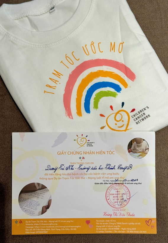 A white shirt with rainbow and a letter

Description automatically generated